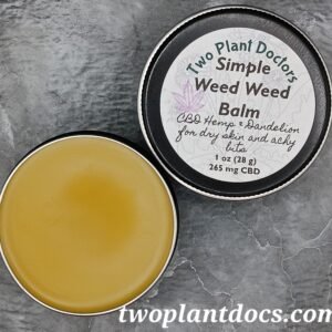 An open tin of a greenish yellow balm and a closed tin