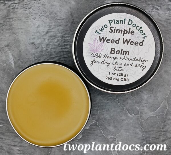 An open tin of a greenish yellow balm and a closed tin