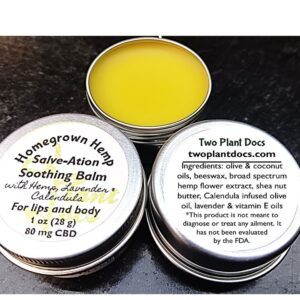 Three round, silver tins. Two with white labels for Salve-Ation Soothing Balm. One with a yellowish balm.