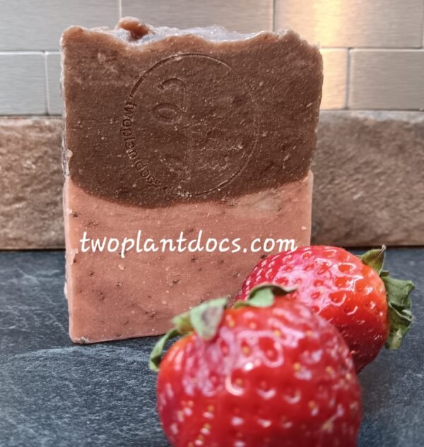 One rectangular brown and pink Chocolate Covered Strawberry Soap and two fresh strawberries