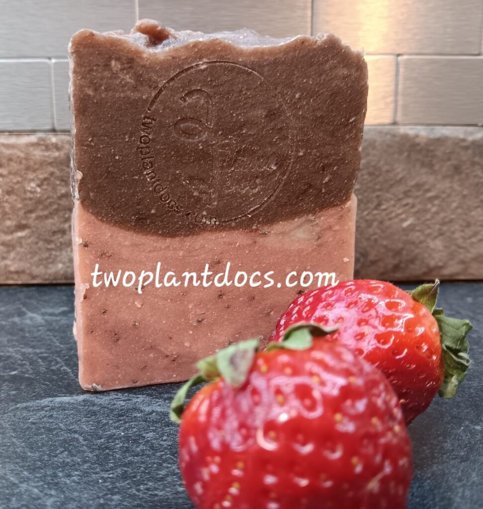 One rectangular brown and pink Chocolate Covered Strawberry Soap and two fresh strawberries