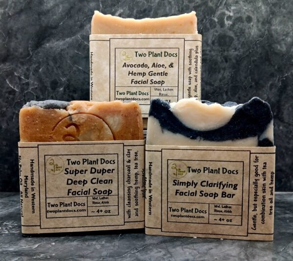 Three square soaps arranged with front showing. One is Avocado, Aloe, and Hemp Gentle Facial Soap. One is Simply Clarifying Facial Soap Bar. One is Super Duper Deep Clean Facial Soap.