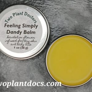 An open tin of bright yellow balm and a closed tin