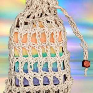 a beige holey crocheted soap saver with a rainbow soap inside