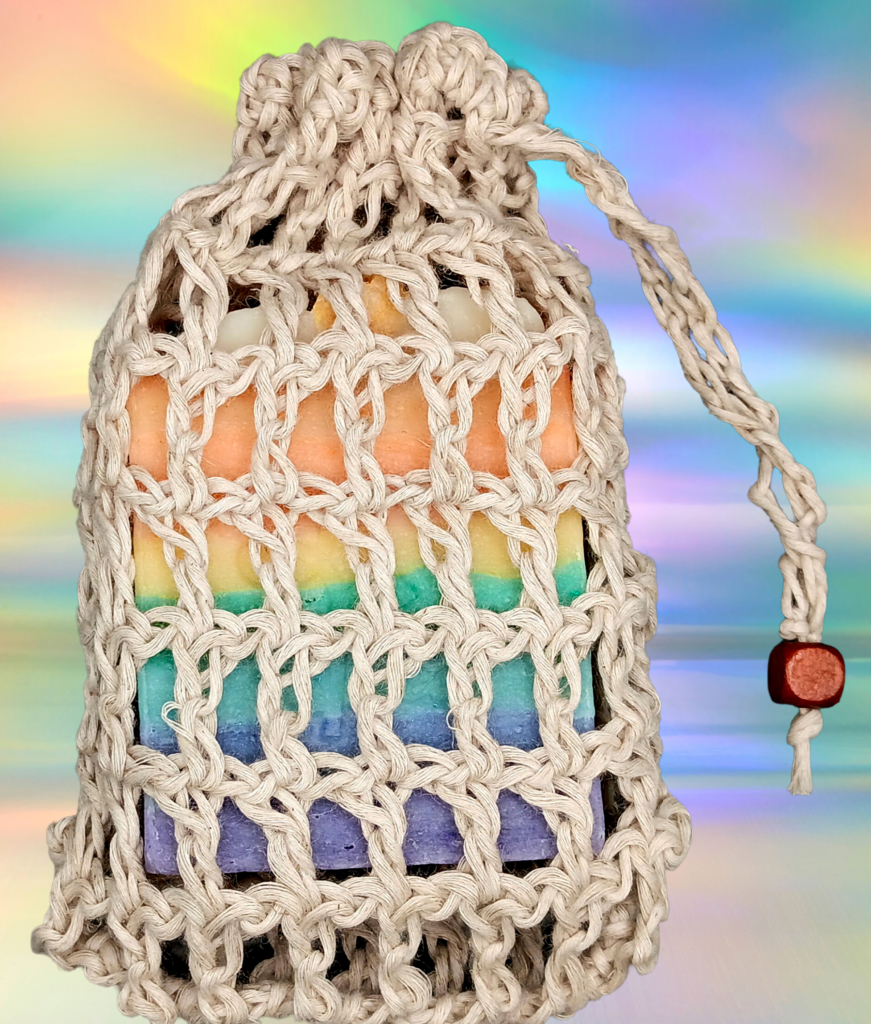 a beige holey crocheted soap saver with a rainbow soap inside