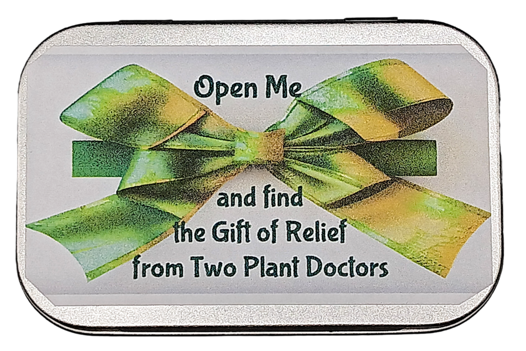 top of a silver rectangular tin with label stating, "Open Me and find the Gift of Relief from Two Plant Doctors"